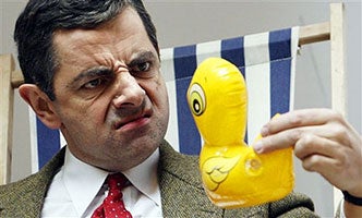 Mr. Bean scowling at a yellow rubber ducky