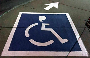 Sidewalk painted with a disability symbol and an arrow